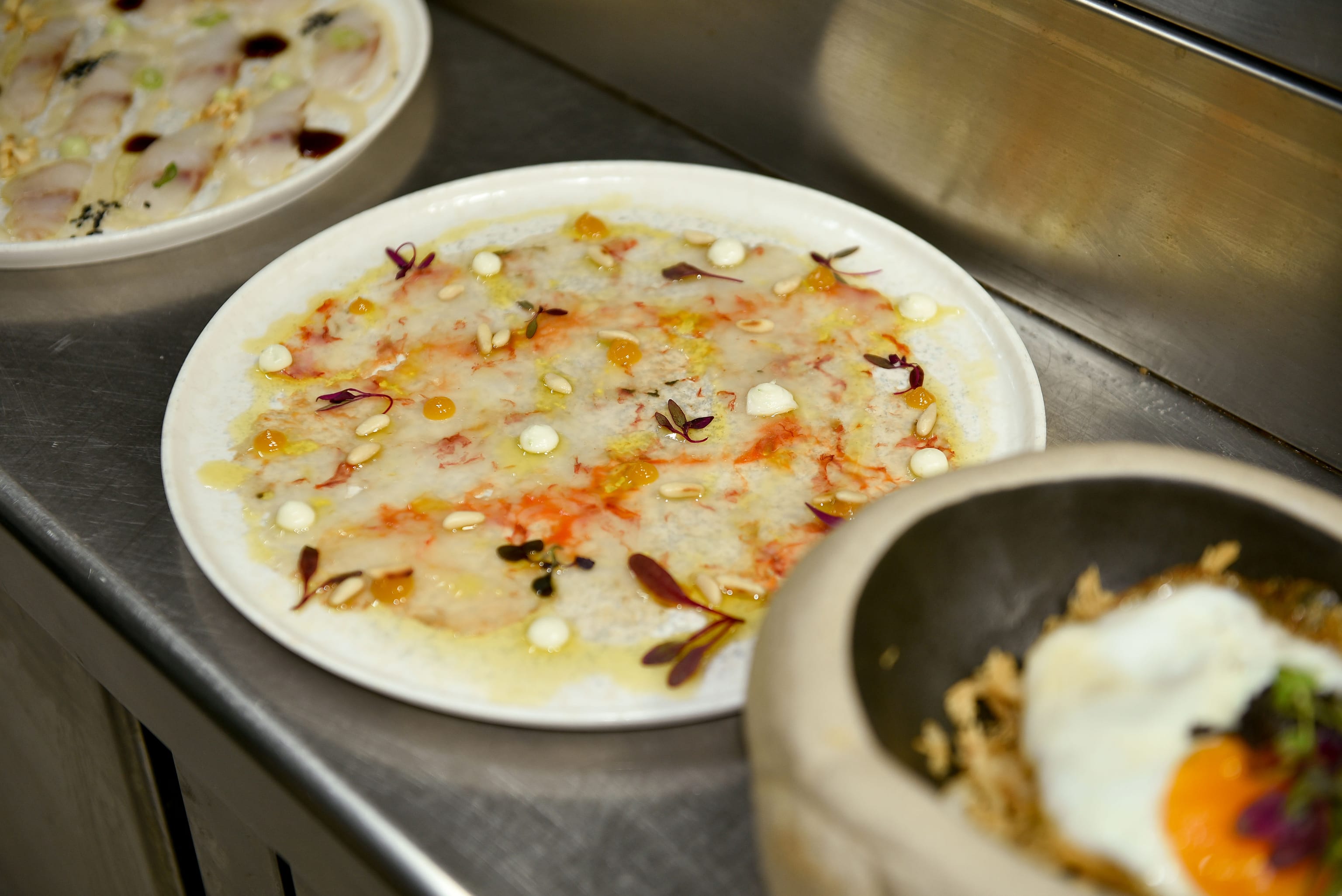 Platos emplatados en el pase de la cocina de The Lot